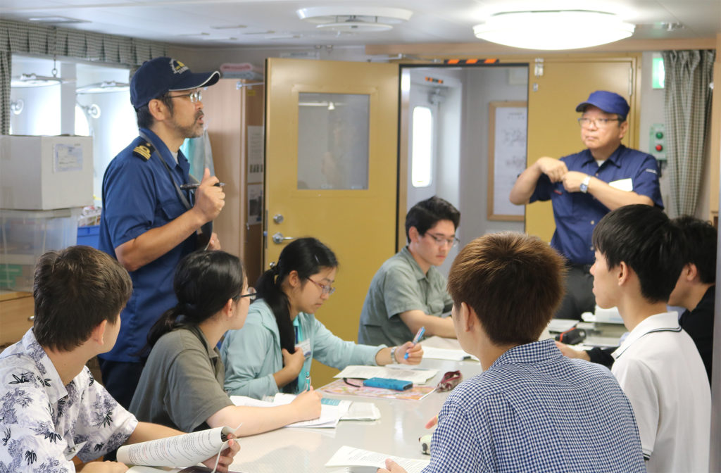 Crew members giving safety instructions and explaining the rules on the ship.