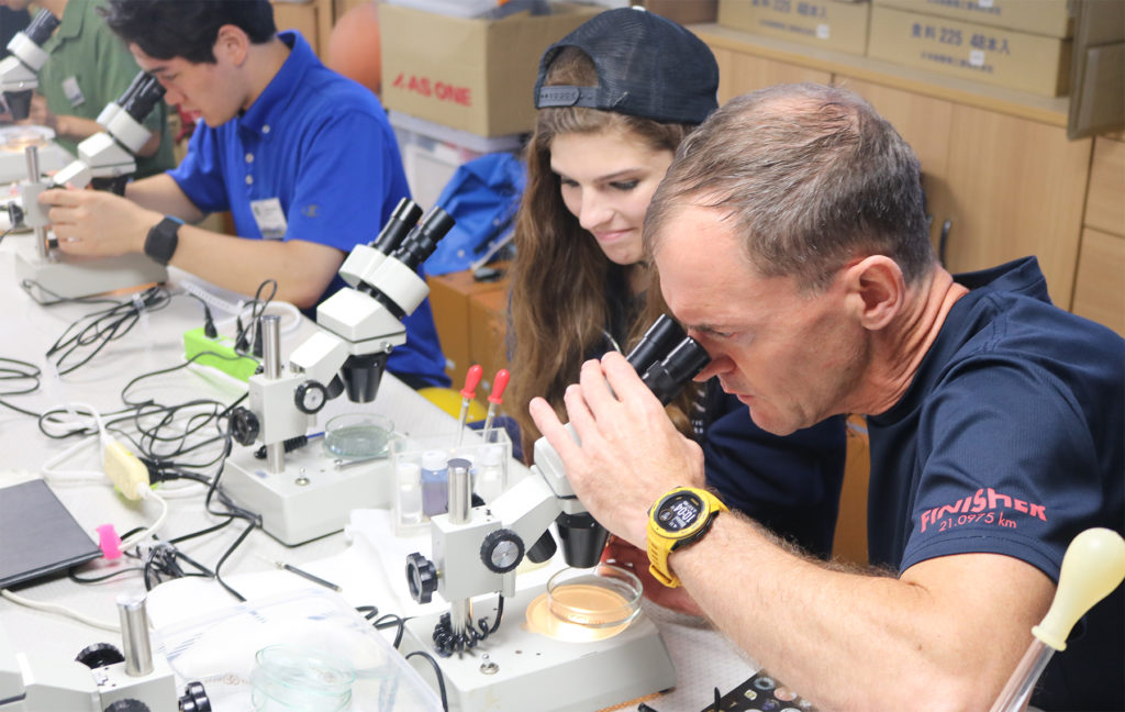 Participants observing planktons sampled from the seawater under the microscope.