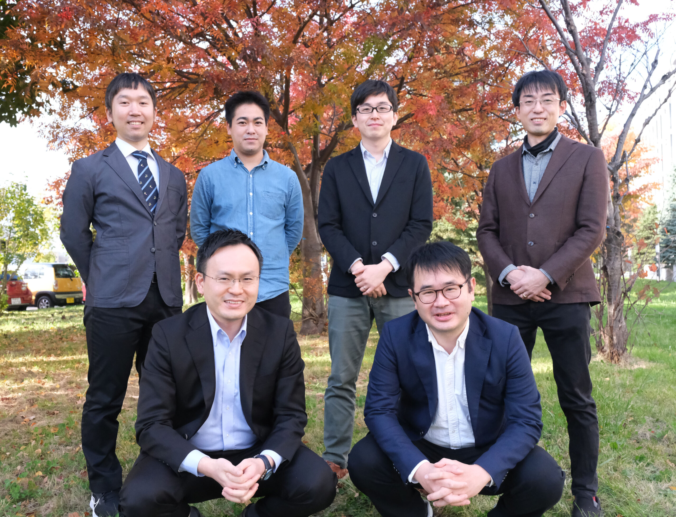 Photograph of researchers from WPI-ICReDD of Hokkaido University.  Top Row, Left to Right: Yu Harabuchi, Wataru Kanna, Hideaki Takano, Hiroki Hayashi.  Bottom row, left to right: Satoshi Maeda, Tsuyoshi Mita.  Photo courtesy of ICReDD.