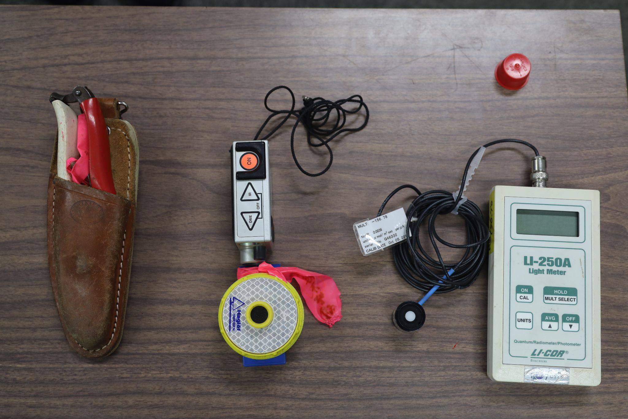 Basic tools for the field survey. From left to right: pruning shears, a tool for measuring tree heights, and a light meter.