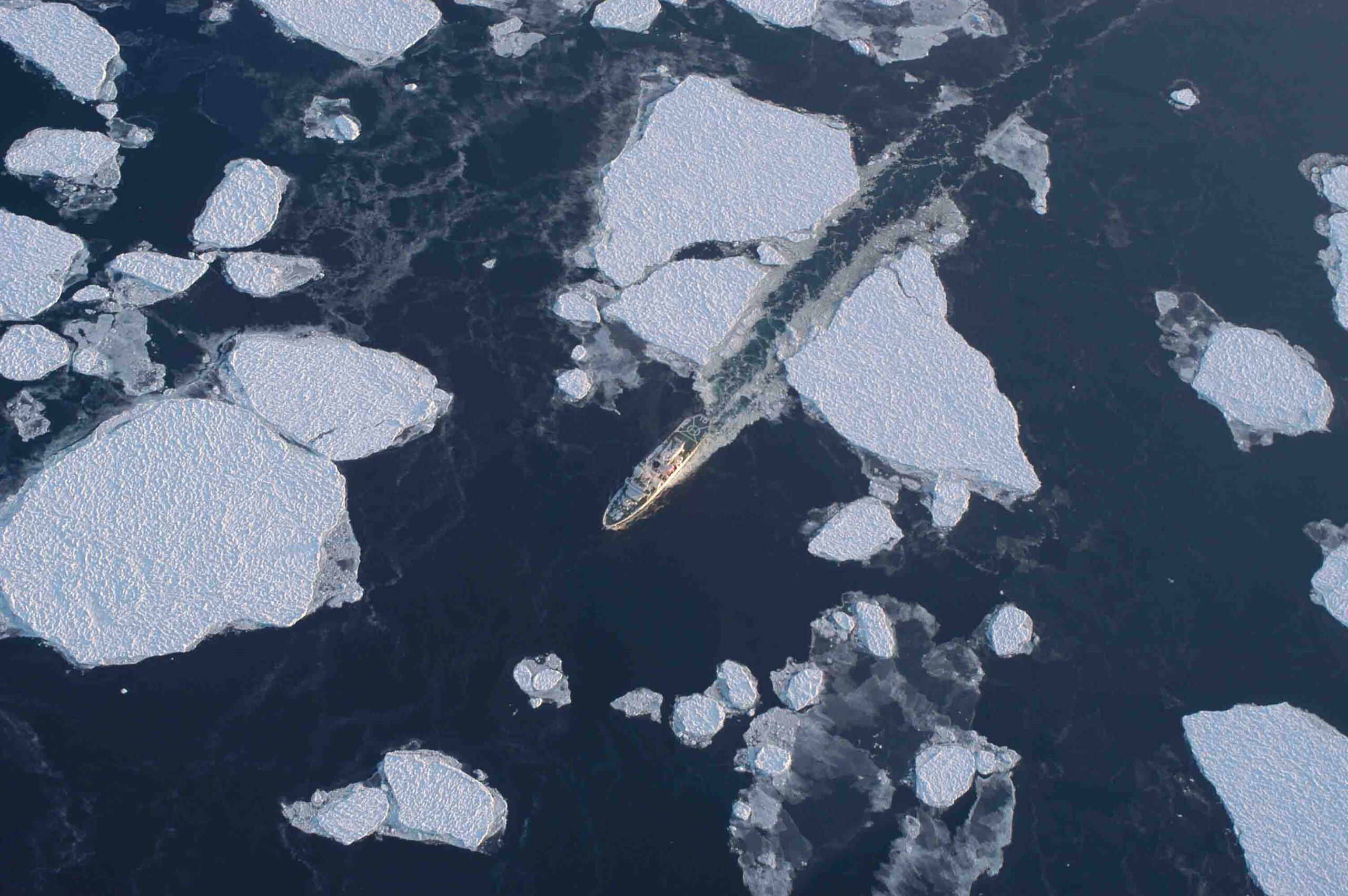 An aerial photograph of the icebreaking patrol vessel "Soya" breaking up sea ice, taken in 2015 by Kay I. Ohshima.