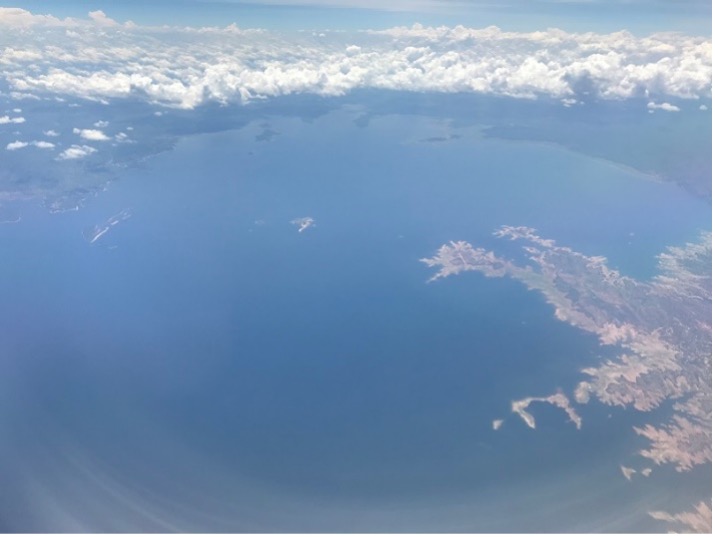 An aerial view of the blue and vast Lake Kariba. Clouds are encircling from top.