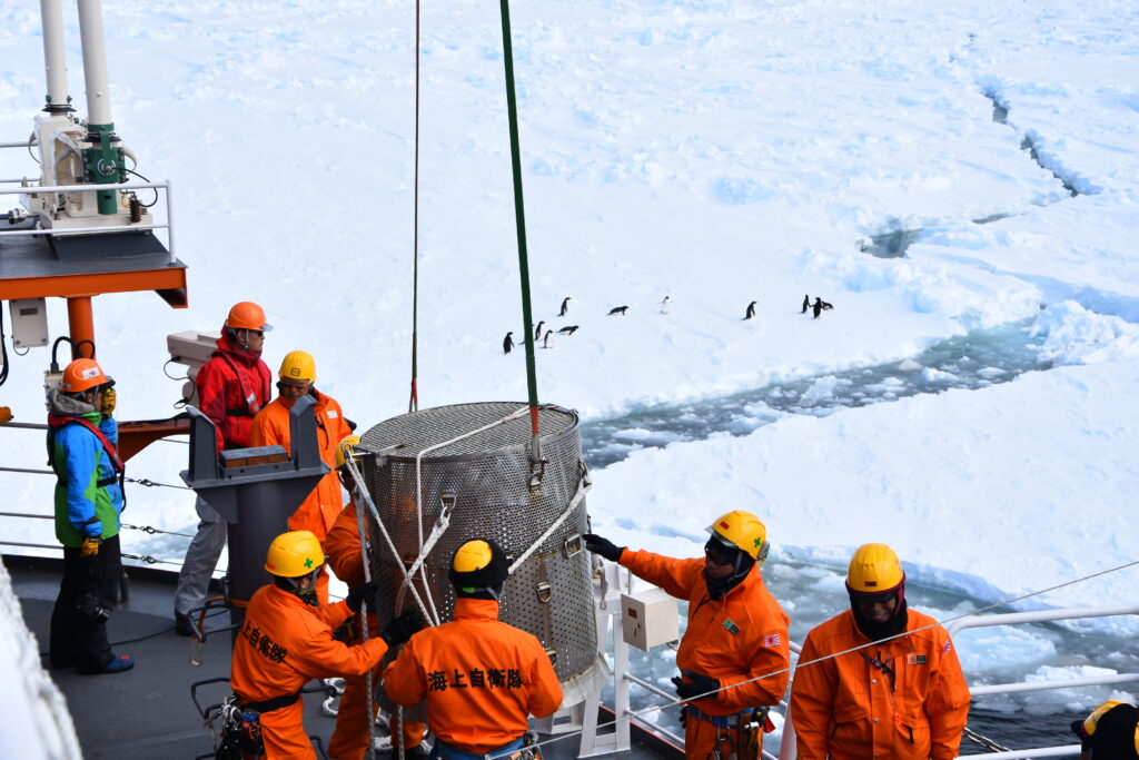 The 61st expedition members lowering observation equipment into the sea (Photo provided by Shigeru Aoki)