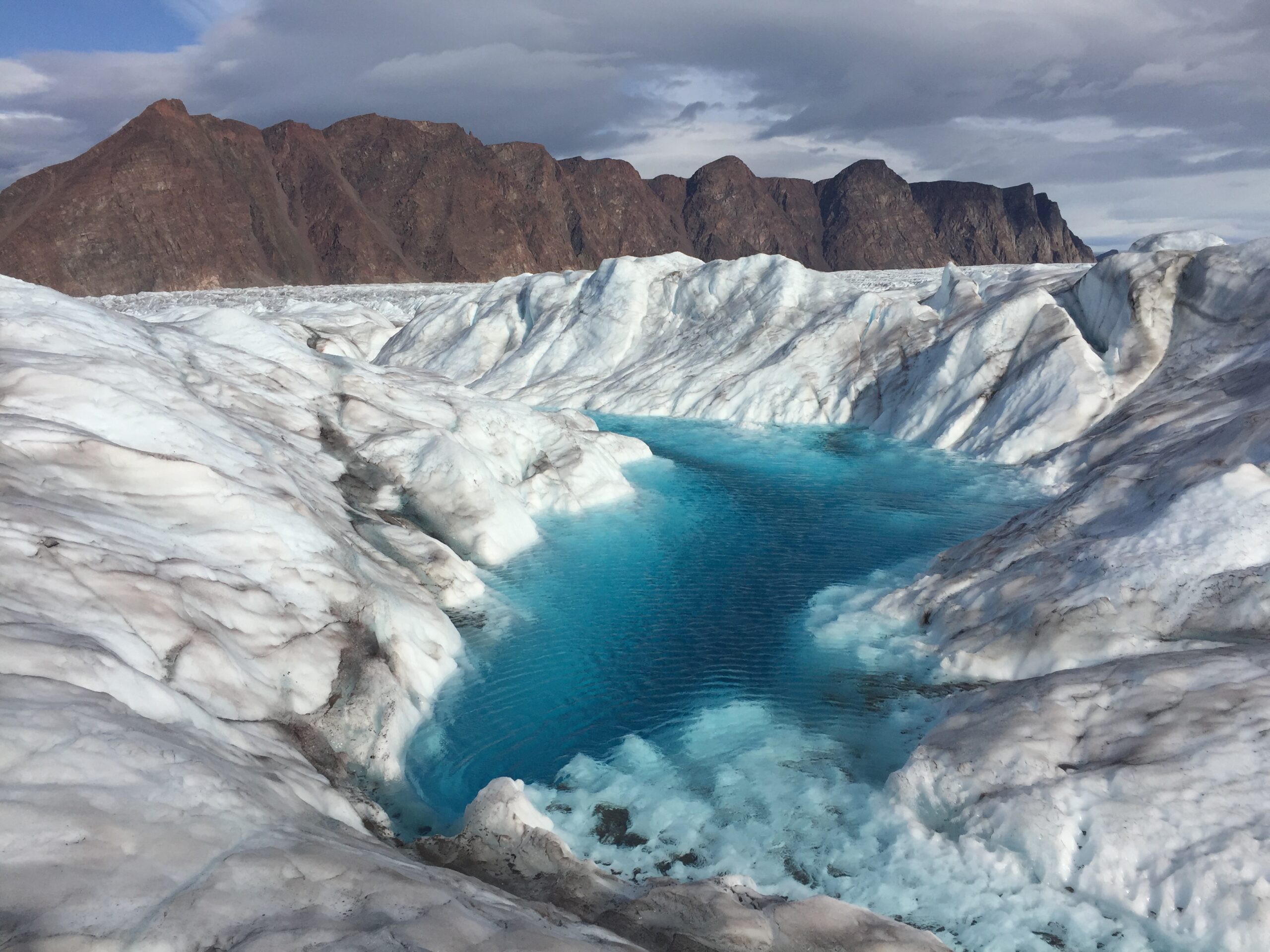Water-filled crevasse at Bowdoin Glacier, Greenland (Photo by Evgeny Podolskiy, 2019).