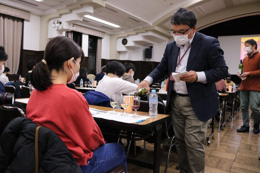 Professor Sone pouring wine. He says that it is important to not only have knowledge but also a sensory experience.