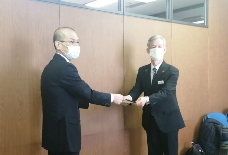 Associate Professor Naoyuki Mikami (left) hands over the Climate Assembly Sapporo 2020 Report to the Director General of the Sapporo City Environment Bureau (right).
