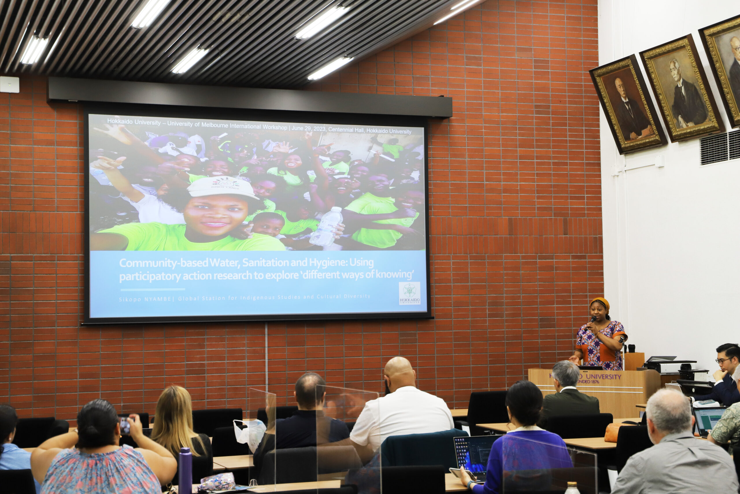 Assistant Professor Sikopo Nyambe speaking about her community-based hygiene practices research in the peri-urban communities in Lusaka, Zambia.